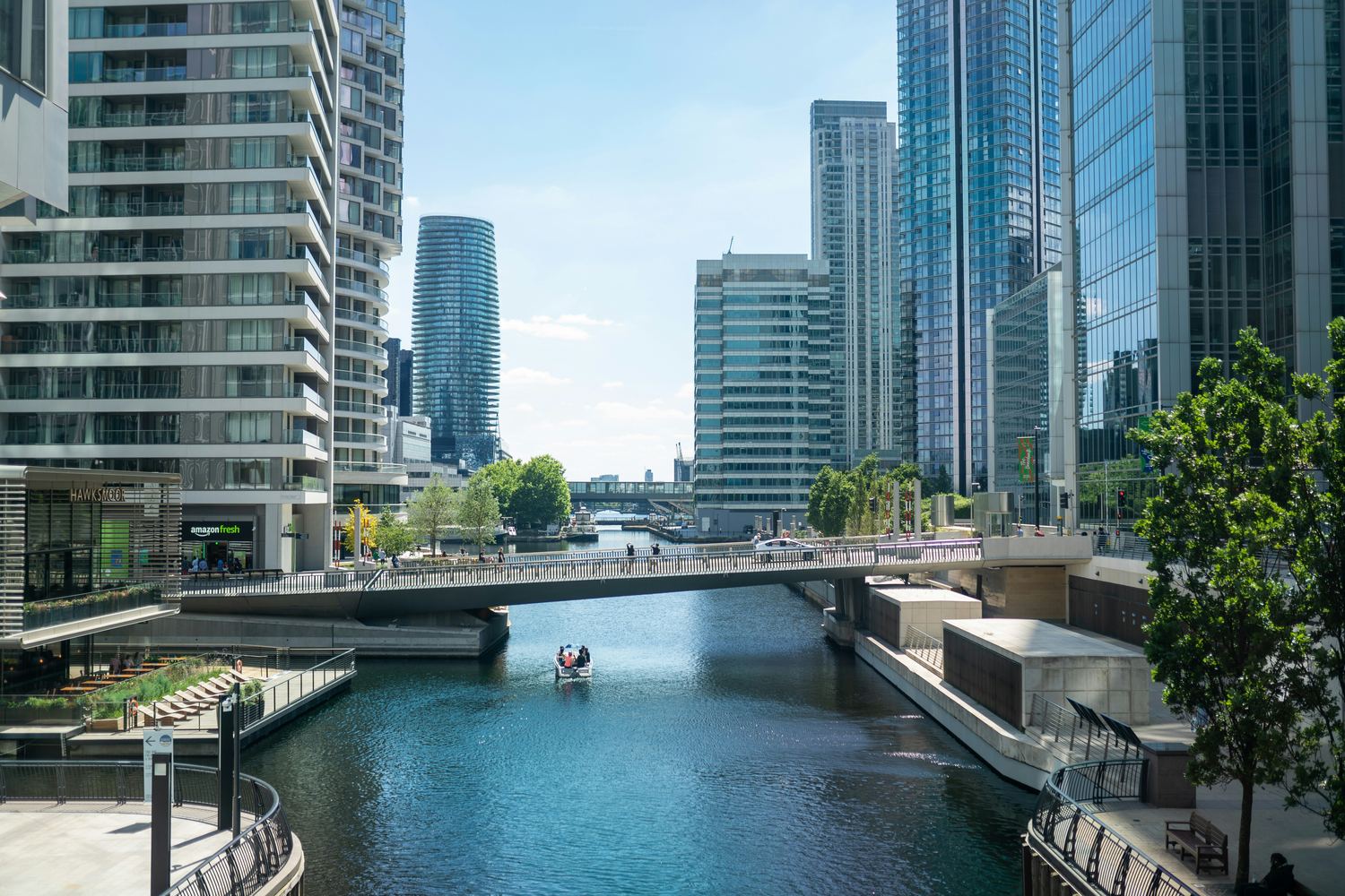 Canary Wharf waterfront in London, with office towers and a footbridge over the dock near ECC’s Churchill Place office